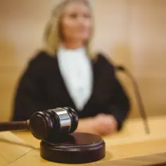 Młotek sędziowski na stole, sugerujący odwołanie od decyzji ZUS. Sędzia w tle.