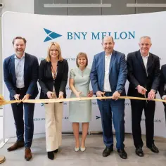 Uroczyste otwarcie z udziałem zespołu BNY Mellon. Pięć osób przecina złotą wstęgę.