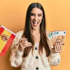Szczęśliwa kobieta z flagą Hiszpanii i banknotami 50 euro. Marzy o pracy w Hiszpanii i dobrych zarobkach.