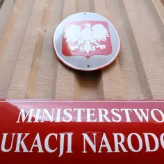 Tablica z godłem Polski i napisem "Ministerstwo Edukacji Narodowej". Zastanawiasz się, ile zarabia nauczyciel mianowany?