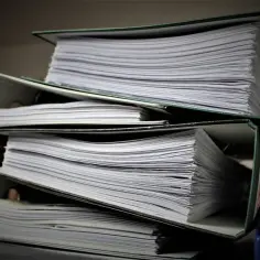 Stosy dokumentów w segregatorach, gotowe do złożenia jako list motywacyjny do urzędu.