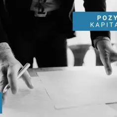 Ręce nad dokumentami, symbolizujące pozyskiwanie kapitału w prostej spółce akcyjnej.
