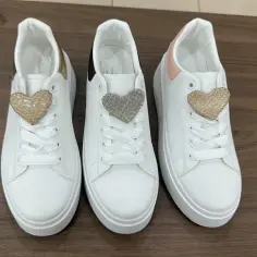 Trzy białe sneakersy z serduszkami. Czy to buty Vices? Firma znana z modnych dodatków.